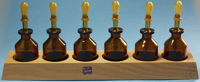 Wooden stands with 6 pipette bottles amber glass,, 50 ml without rubber teats...